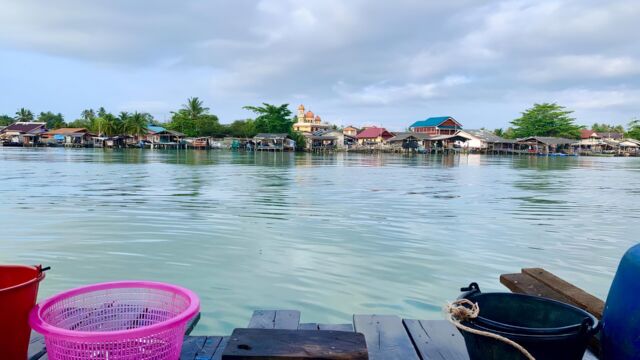 View of a fishing village including mosque from water.