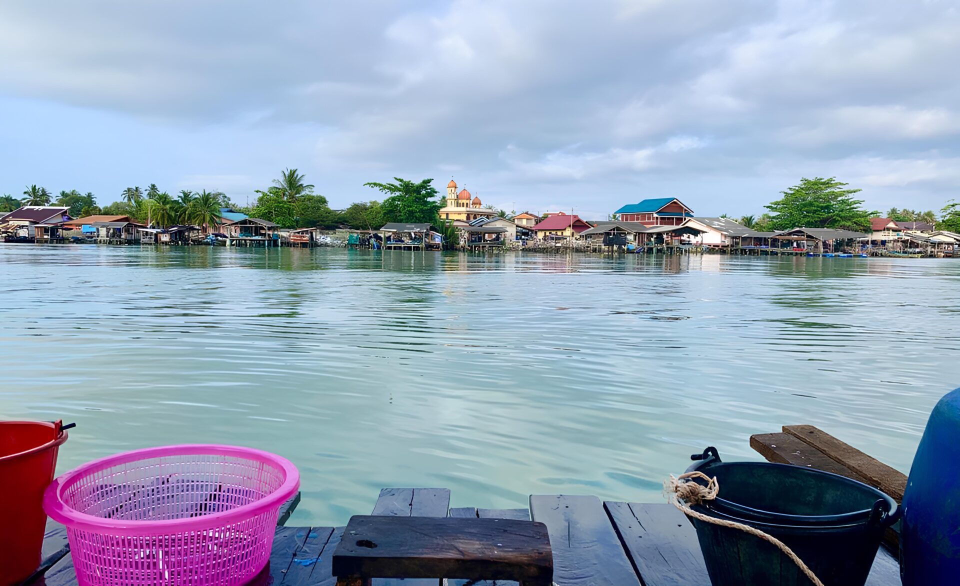 View of a fishing village including mosque from water.