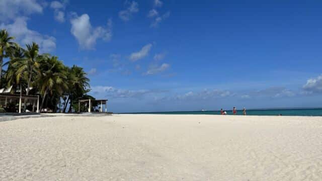 A beach with white sand and blue sky.