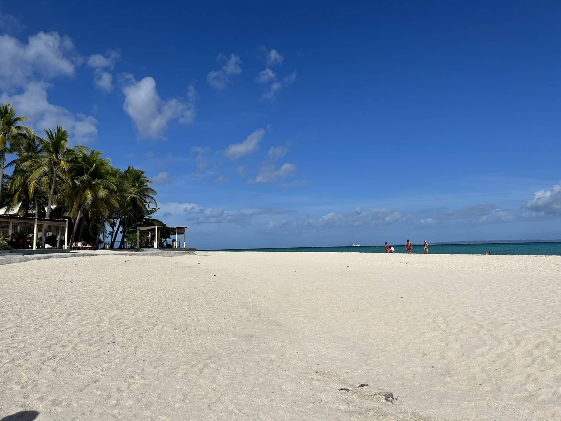 A beach with white sand and blue sky.