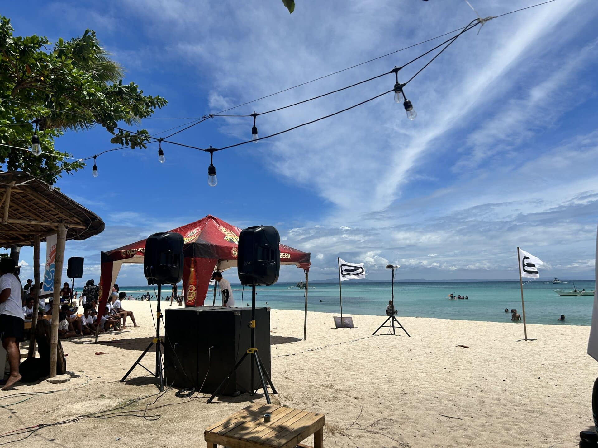 Sound systems, flags and tourists on the beach.